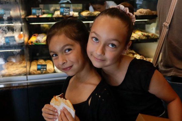 Six-year-old Abigail, left, takes a bite out of a cookie after ballet practice on Oct. 11. Torrance Bakery proudly serves performers from Abigail and her friend Penelope to megastars including Taylor Swift.