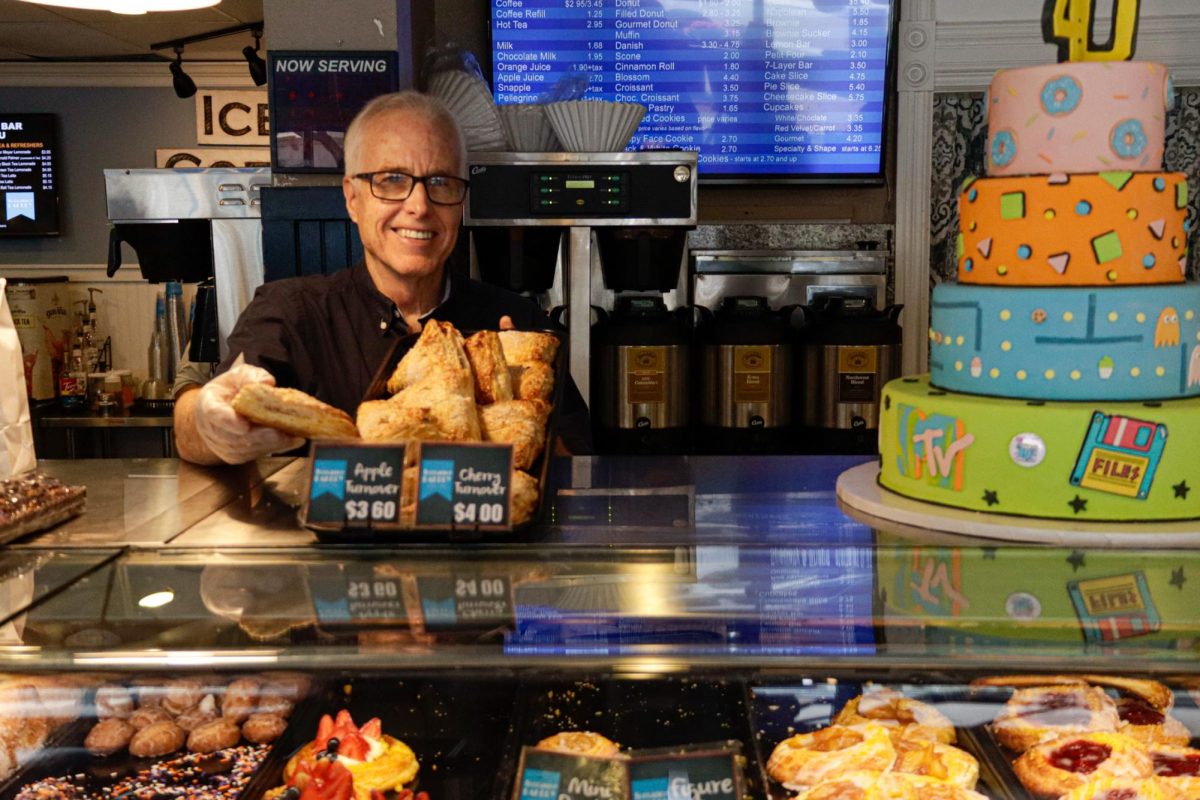 Kirk Rossberg dishes out an apple turnover at Torrance Bakery on Oct. 11, 2024. Rossberg is the owner and president of Torrance Bakery, a local institution that has been serving cookies, donuts and cakes to the South Bay for 40 years. (Erica Lee | Warrior Life)