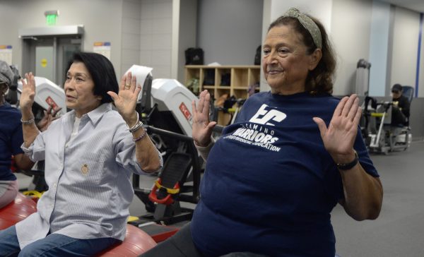 Carole Hoshiko, left, and Salma Farkouh exercise while sitting on a yoga ball on Oct. 24, 2024 at the Adapted Fitness Room. (Angel Pasillas | Warrior Life)