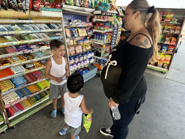 Cassandra Gonzalez picks out snacks with her sons, Moises "West" Cisneros (left) and Joseph "JJ" Cisneros Struthers at Alta-Dena Market on Imperial Highway in Inglewood, Calif. on May 1, 2024. (Kim McGill | Warrior Life)