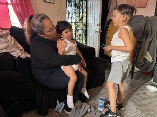 Cassandra Gonzalez comforts her two-year-old son, Joseph "JJ" Cisneros Struthers, at her home in Inglewood, Calif. on May 1, 2024. Her other son, five-year-old Moises "West" Cisneros (right) offers advice. (Kim McGill | Warrior Life)