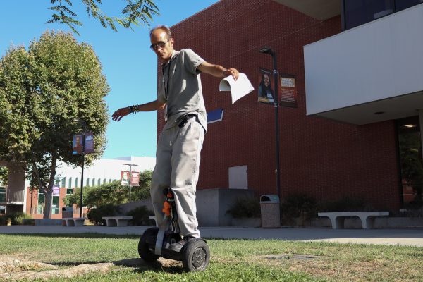 Alex Fleming, 34, rides "Tail" the Segway outside the Schauerman Library on Sept. 26.