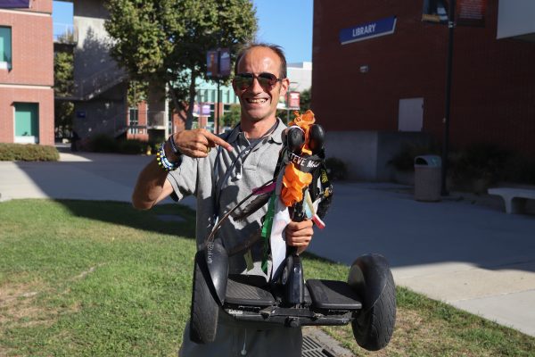 After purchasing "Tail" the Segway, it took Fleming, pictured here with his scooter on Sept. 26, about two to three minutes to learn to ride the scooter. Tail is treated with care and Fleming refers to it as his “noble steed,” which is a reference to the "Shrek" movie franchise. (Eddy Cermeno | Warrior Life)