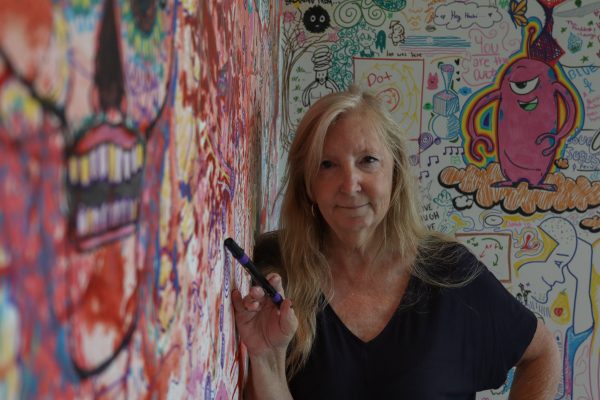 Carrie Lockwood, El Camino College Art Gallery associate, points a purple marker in front of the doodle art wall inside the gallery on Oct. 10. Lockwood is an associate at the gallery where she helps manage, plan and organize artwork that goes into the gallery for exhibitions. “Being exposed to all the creativity while being in the gallery, learning about different cultures and art practices is phenomenal,” Lockwood said. (Eddy Cermeno | Warrior Life)