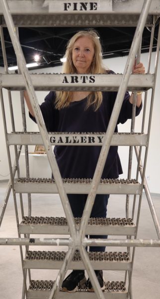 Carrie Lockwood, El Camino College Art Gallery associate, climbs and poses on a step-ladder inside the gallery on Tuesday, Oct. 15. Lockwood is cautious when using the ladder to work on the walls to hang or remove artwork. (Eddy Cermeno | Warrior Life)