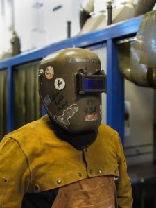 Welding instructor Albert Sandoval, 26, wears a passive helmet covered with stickers in the Center for Applied Technology at El Camino College on Oct. 7. Welders wear these helmets to protect their eyes from ultraviolet radiation and infrared light. (Chelsea Alvarez | Warrior Life)