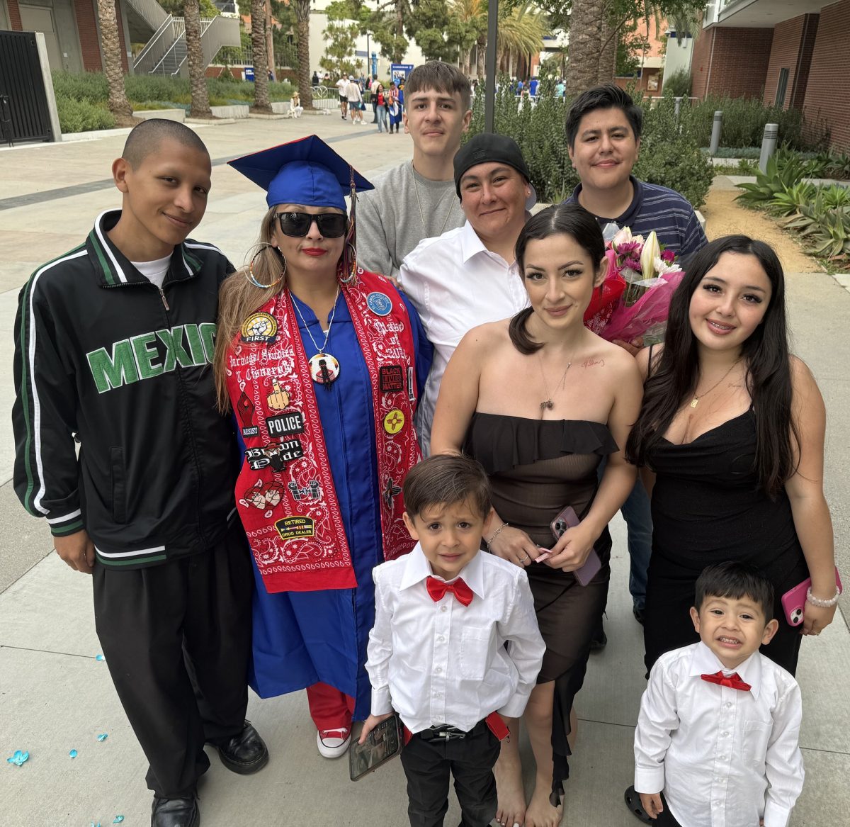 El Camino College Guardian Scholar, Cass Cisneros (center left), graduates from El Camino College on June 7. Her family and friends are there to cheer her on, including her children, Jonathan Orozco (center back), Savannah Valdez (middle), Elisyannah Valdez (middle right), Moises “West” Cisneros (front center) and Joseph “J.J.” Cisneros Struthers (front right). (Kim McGill | Warrior Life)