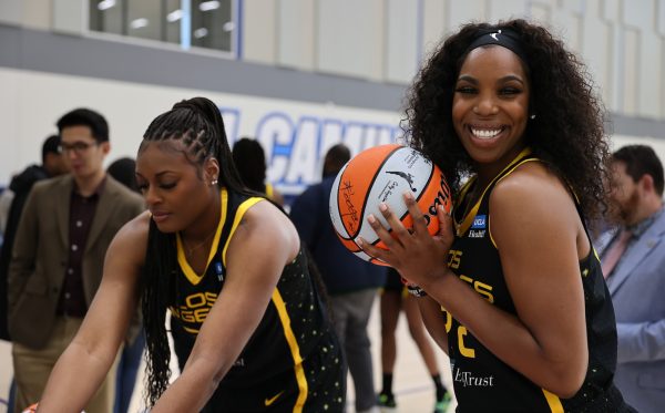 Los Angeles Sparks players Joyner Holmes (left) and Reshanda Gray sign several basketballs to give to sponsors of the Sparks during media day at the gymnasium on May 4. (Khoury Williams | The Union)