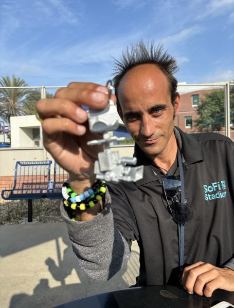 Alex Fleming, 34, holding one of his many #D printed models. This specific model is a replica of Sofi Stadium's skycap.