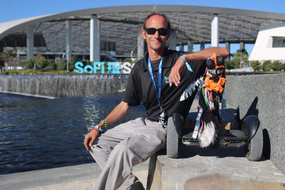 Alex Fleming, 34, poses with his trusted micro mobility device, "Tail" the Segway, in front of Sofi Stadium on Oct. 23. Fleming has accumulated over 4,000 miles and counting on his micro mobility device. Traveling to school, work and back home, this engineering student has built a unique connection with his self-balancing scooter. (Joseph Ramirez | Warrior Life)