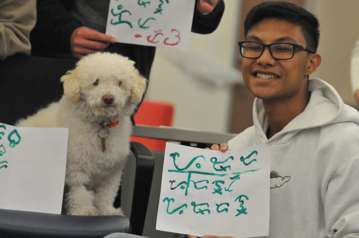 Jordan Consul, 19, a member of the Barkada Club shows off his calligraphy writing. (Taheem Lewis | The Union)