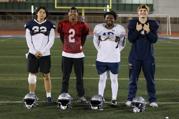 From left to right: International and out-of-state student-athletes defensive back Yudai Naka, wide receiver Elijah Holmes, running back Aaron Nelson and linebacker Mathis Schaaf stand together as a team on Murdock Stadium. (Renzo Arnazzi| The Union)