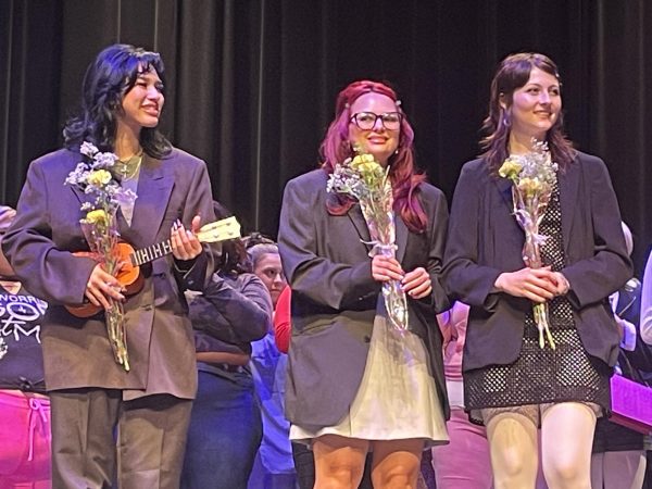 Noelle Boyd, center, and her fellow graduating classmates receive flowers at the conclusion of the 5th annual hair show on Dec. 4.