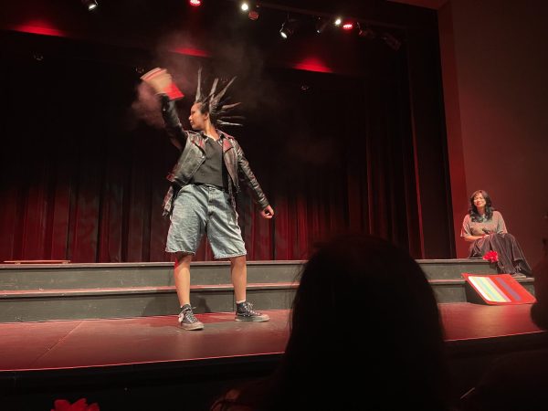 A model representing the punk aesthetic of the 90s adds a layer of hairspray to her liberty spikes during a performance at the El Camino College cosmetology department's 5th annual hair show at the Campus Theatre on Dec. 4.