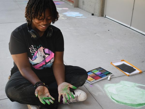 Studio art major Ruth Kembay, 20, works with chalk and soft pastel outside the El Camino College Art Gallery on Monday, June 2. Kembay was drawing spells and items from Dungeons and Dragons, including "Tasha&squot;s Hideous Laughter," "Hunger of Hadar," fireballs and dice. (Nikki Yunker | The Union)