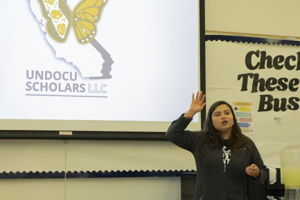 Student Success Coordinator at the El Camino College DREAM Center announces the business card bulletin where students can leave their business cards during the Undocuscholars LLC. guest speaker Aldo Cruz presentation on Wednesday, Oct. 22, 2025. The Undocuscholars is an organization that visits schools and does workshops for immigrant and undocumented students. Their vision seeks to create "future where educational institutions serve as beacons of belonging, where students—regardless of their immigration status—are fully supported in their academic and personal journeys, according to their website. (Oriana de Quay | The Union)