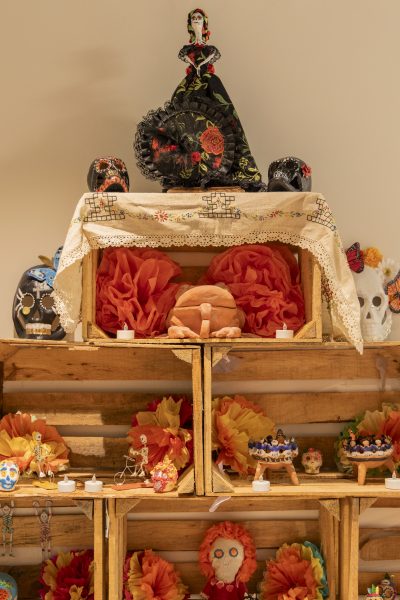 Altar in El Camino College Art Gallery curated by Dulce Stein holds figures and sugar skulls representative of Hispanic Heritage. Dia De Los Muertos takes place Nov. 1, but the gallery celebrated on Thursday, Oct 30, 2025, with sugar skull face painting, dancing and displayed artworks by Hispanic Artists. (Oriana de Quay | The Union)