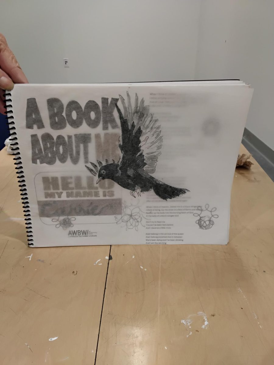 Carrie Lockwood, El Camino College's Art Gallery participant, with her book, "A Book About Me," which was given to her by her therapist. Students will have the opportunity to explore the book and add to it as well. (Paula Cunningham) Photo credit: Paula Cunningham