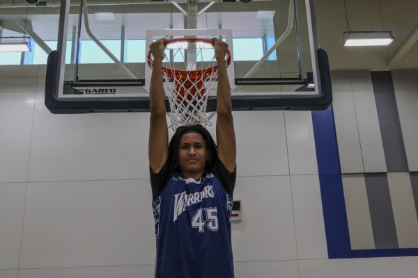 El Camino basketball player Joshua Bada hangs on the rim in the Gym Complex on Dec. 5. (Donovan Harris | The Union)