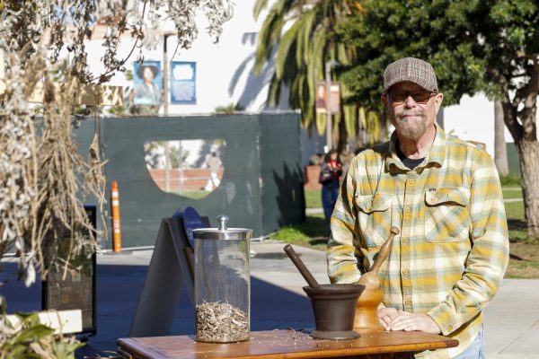 Michael Miller, who is the Director of the Gallery and Museum Programming, explaining his aromatherapy station outside of the gallery, which is meant to bring students some peace and comfort, on Nov. 19, 2025. [Seph Peters | The Union]