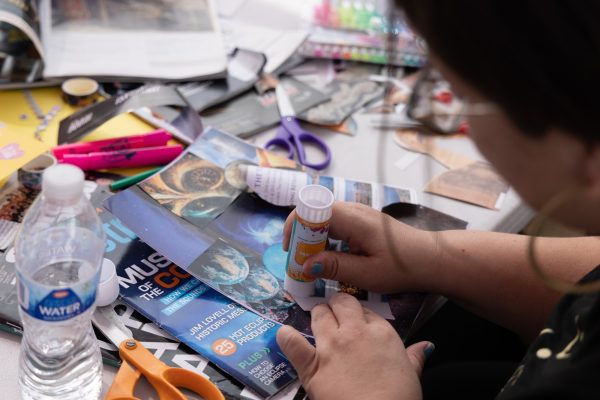 Theatre major Cassandra Rivera, 37, uses a glue stick to collage magazine clippings into a vision board project at the El Camino College Center for Well-Being on Tuesday, Feb. 24. Rivera, who used images sourced from travel and astronomy magazines, said her vision board represents starting a new life. (Nikki Yunker | The Union)