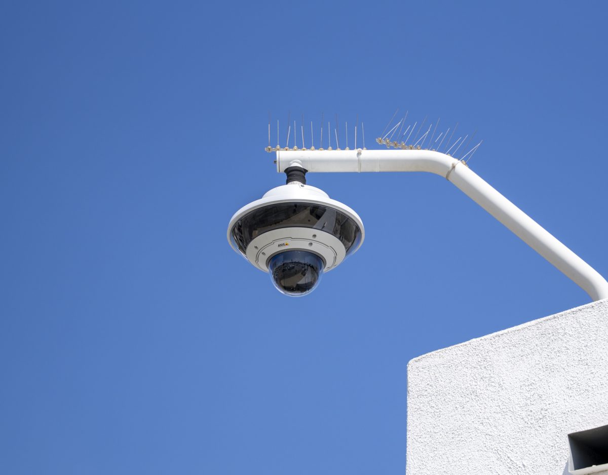 A security camera mounted on the exterior of the campus police station, positioned above the police vehicle parking lot, monitors Lot K using the Omni Ai system. (Gael Gallardo | The Union)