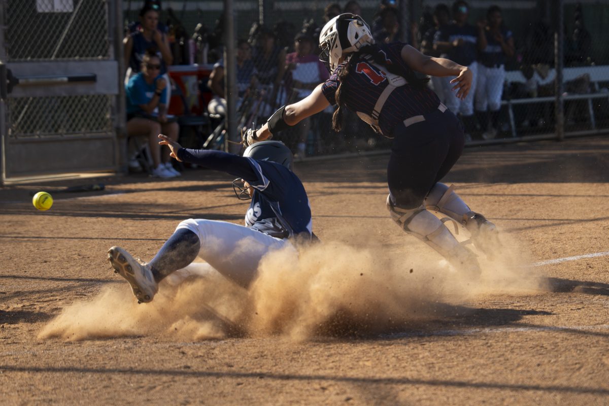 El Camino College's Melissa Terrazas slides into home plate and scores after a throw gets past the Orange Coast catcher on Wednesday, March 18. (Gael Gallardo | The Union)