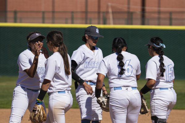 El Camino College players gather around eachother before their second game in a double header against LA Mission College at the ECC softball field on Saturday, March 7. The Warriors beat LA Mission in both games with scores of 5 - 3 in the first game and 11 - 3 in the second game. IRyan Hirabayashi | The Union)
