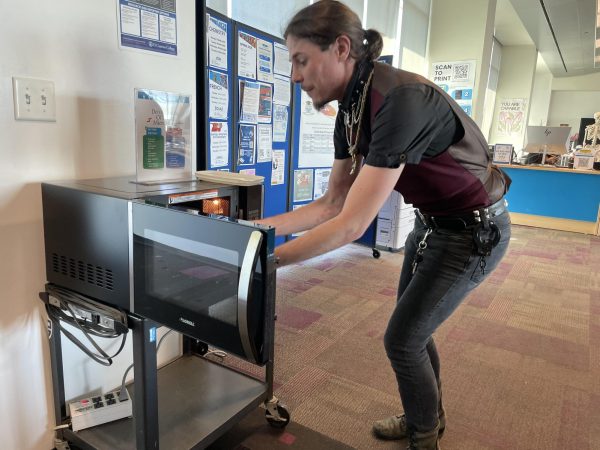Psychology student David Staley, 25, takes out his lunch from a new microwave in the Tutoring Center Tuesday, March 17. The microwave is one of two donated by the Basic Needs Center after the old microwaves broke due to a combination of electrical surges and misuse. (Erica Lee | The Union)