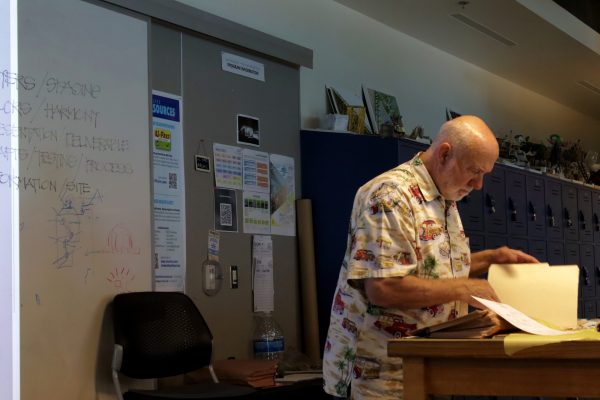 El Camino College's architecture instructor, Daniel Richardson, 75, opens a binder of paperwork before handing copies out to his students at the Industry Tech Building on April 7th, 2026. (The Union | Patrick Martinez)