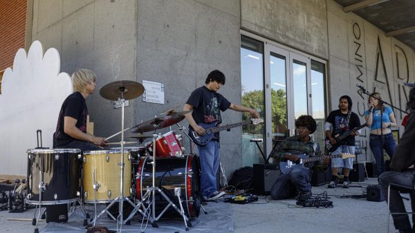 Band tunes their instruments before their performance in the Battle of the Bands event hosted by the Society of Music club in front of the El Camino college Art Gallery on Monday, April 27. (Zaire Miranda | The Union)